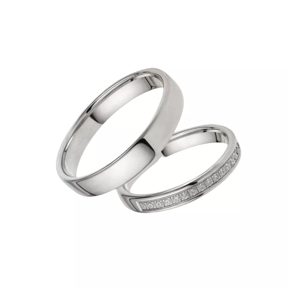 Alianzas en oro blanco pulido con 20 diamantes talla brillante. Espesor: 3 mm (ella) y 4 mm (él). Peso total: 7.5 gr.