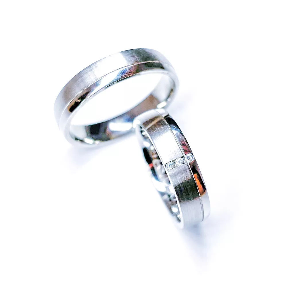 Alianzas en oro blanco pulido y satinado con 3 diamantes talla brillante. Espesor: 5 mm. Peso total: 11 gr. 