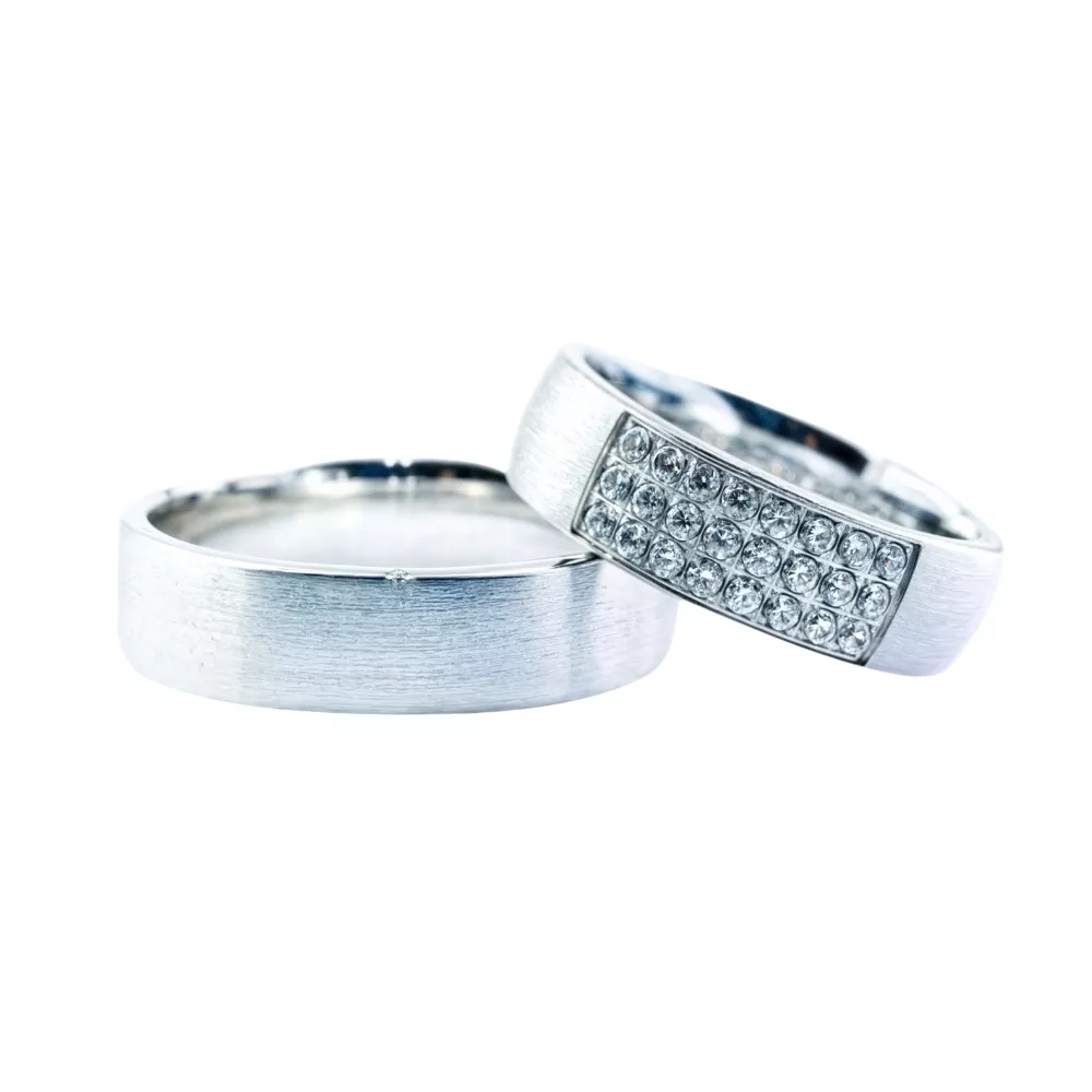 Alianzas en oro blanco satinado con 24 diamantes talla brillante. Espesor: 6 mm. Peso total: 16 gr.