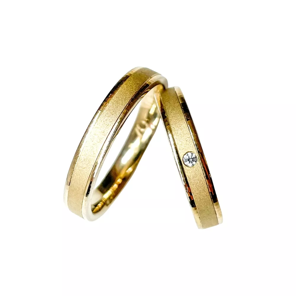 Alianzas en oro amarillo pulido y arenado con 1 diamante talla brillante. Espesor: 4 mm. Peso total: 8 gr.