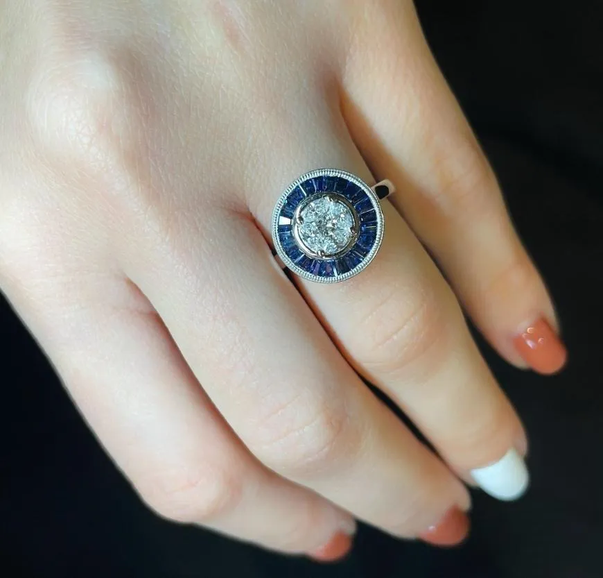 Ring in platinum set with marquise-cut diamonds, princess-cut diamond and baguette-cut sapphires.