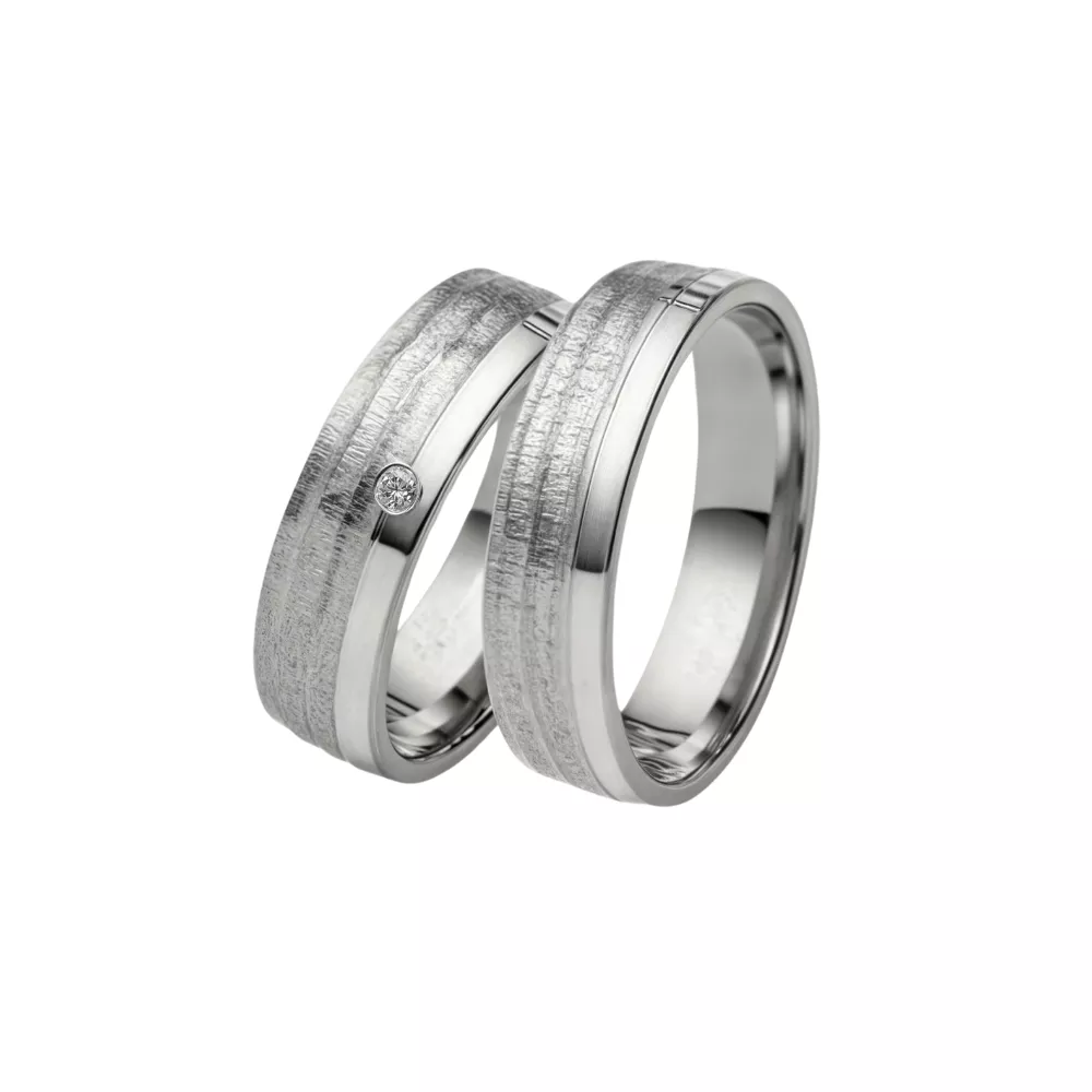 Alianzas en oro blanco pulido y satinado con 1 diamante talla brillante. Espesor: 5 mm. Peso total: 12 gr. 