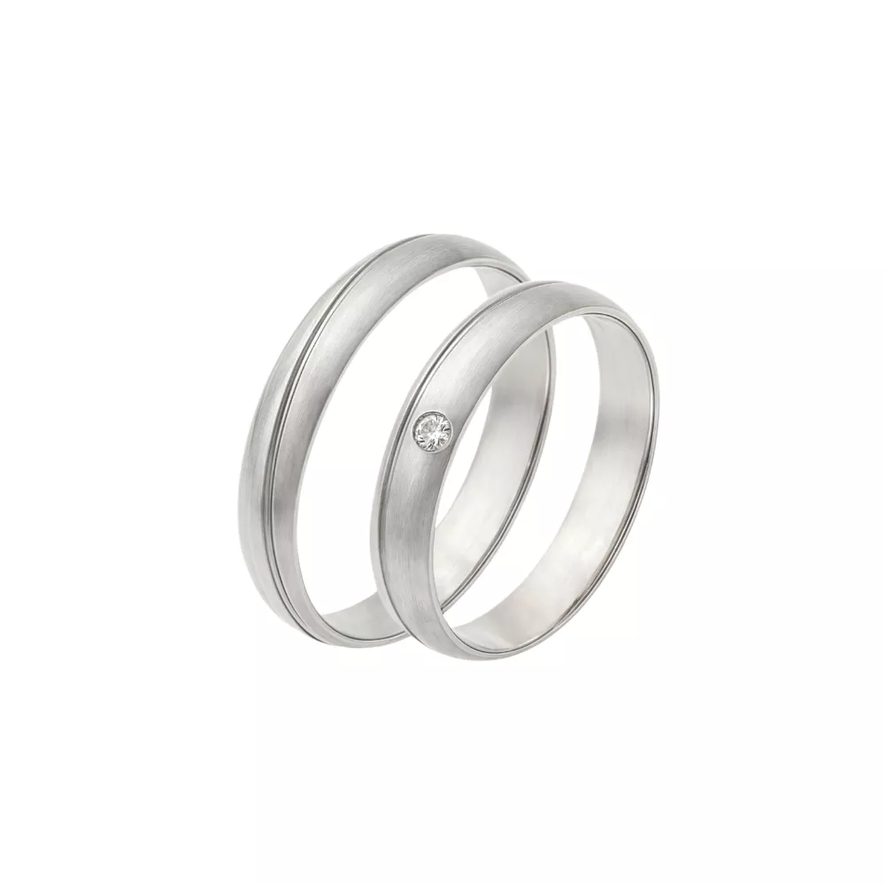 Alianzas en oro blanco pulido y satinado con 1 diamante talla brillante. Espesor: 4 mm. Peso total: 7.5 gr. 