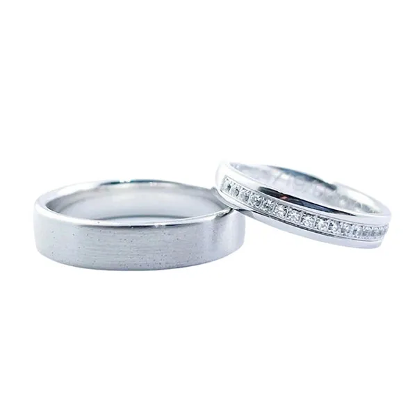 Wedding bands in white gold set with brilliant-cut diamonds. Thickness: 4 mm (her) and 6 mm (him). Total weight: 11 gr.