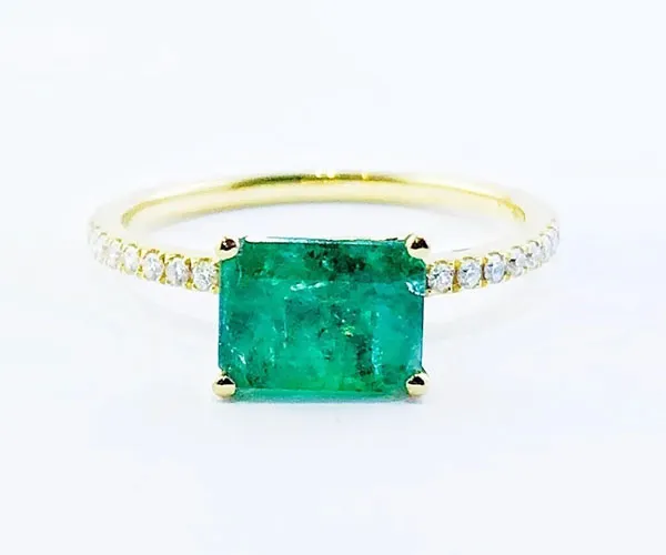 Ring in yellow gold set with emerald-cut emerald and brilliant-cut diamonds.